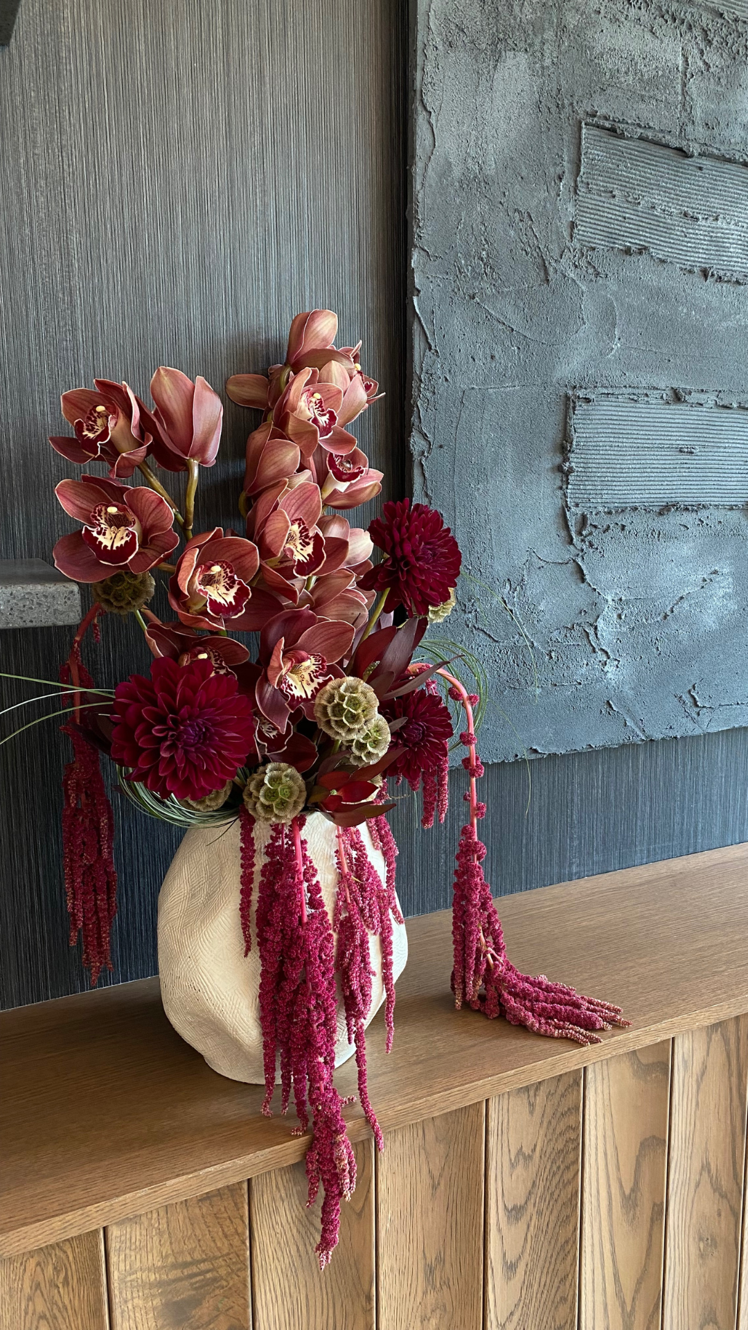 Orchids and Dahlias in a flower arrangement next to a stunning art installation at the Ada Hotel